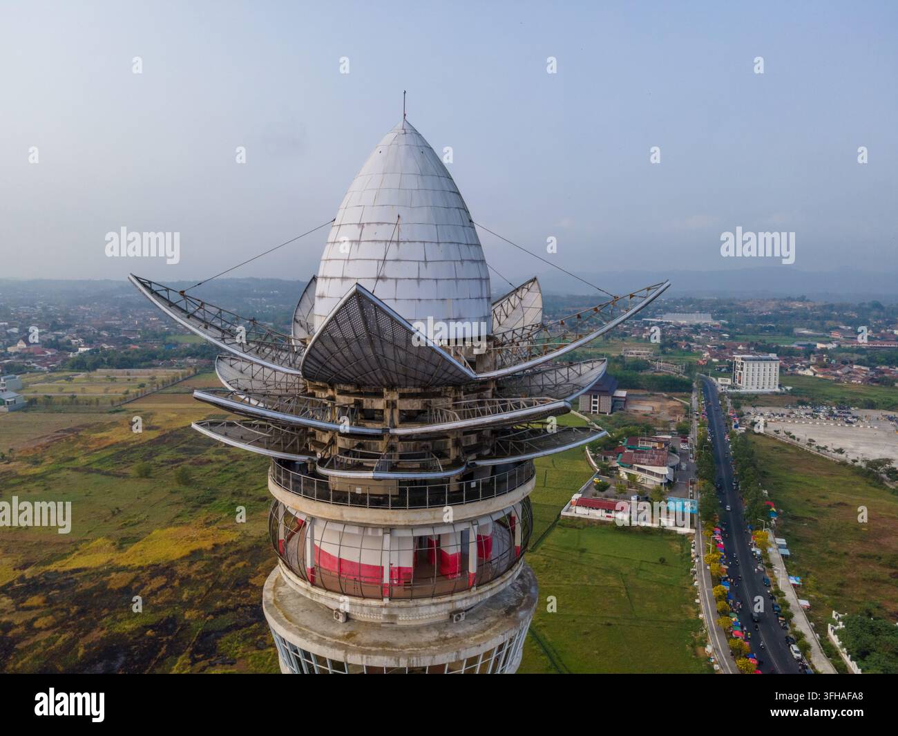 Vue aérienne de la tour d'observation Menara Pandang Teratai en forme de lotus avec dôme métallique et structures en forme de pétale, surplombant la ville de Purwoke Banque D'Images