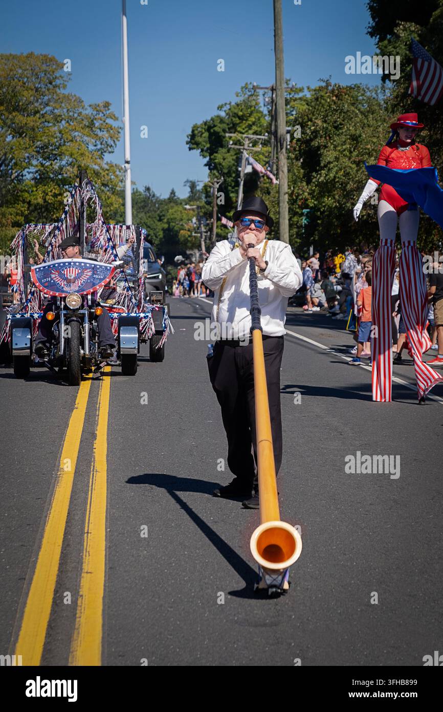 Pendant la parade du Labor Day de Newtown en 2026, une fanfare joue d’un long cor sur roues appelé alphorn ou alpenhorn. Banque D'Images