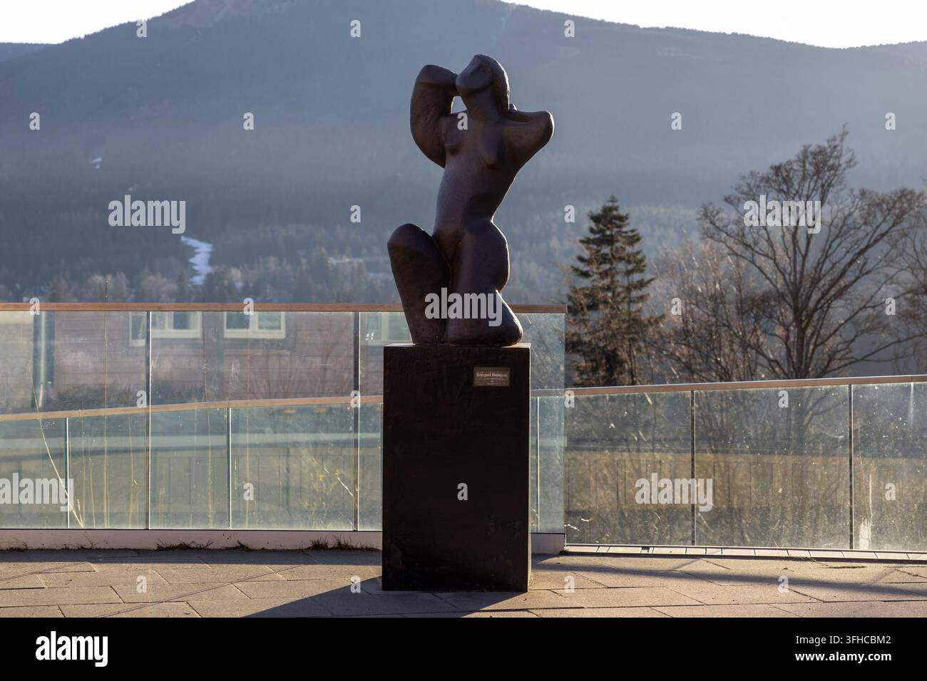 Szklarska Poręba, Pologne – 16 décembre 2025 : Élegante sculpture en bronze sombre d'une figure féminine aux bras levés, reflétant l'harmonie avec la nature Banque D'Images