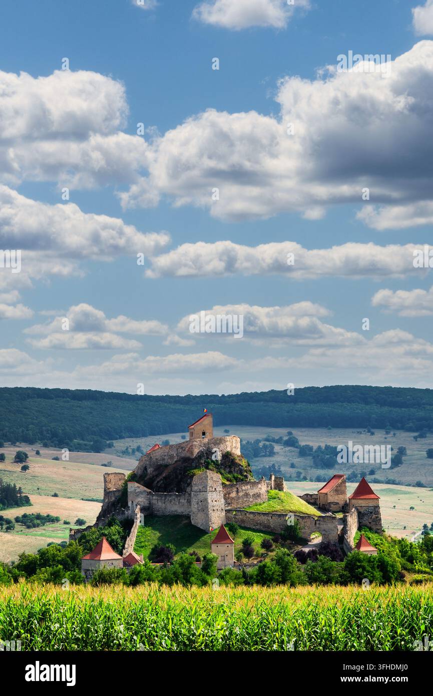 Citadelle médiévale de la forteresse de Rupea dominant une campagne verdoyante ondulée et des champs de maïs sous un ciel nuageux dramatique, Rupea, Transylvanie, Roumanie Banque D'Images