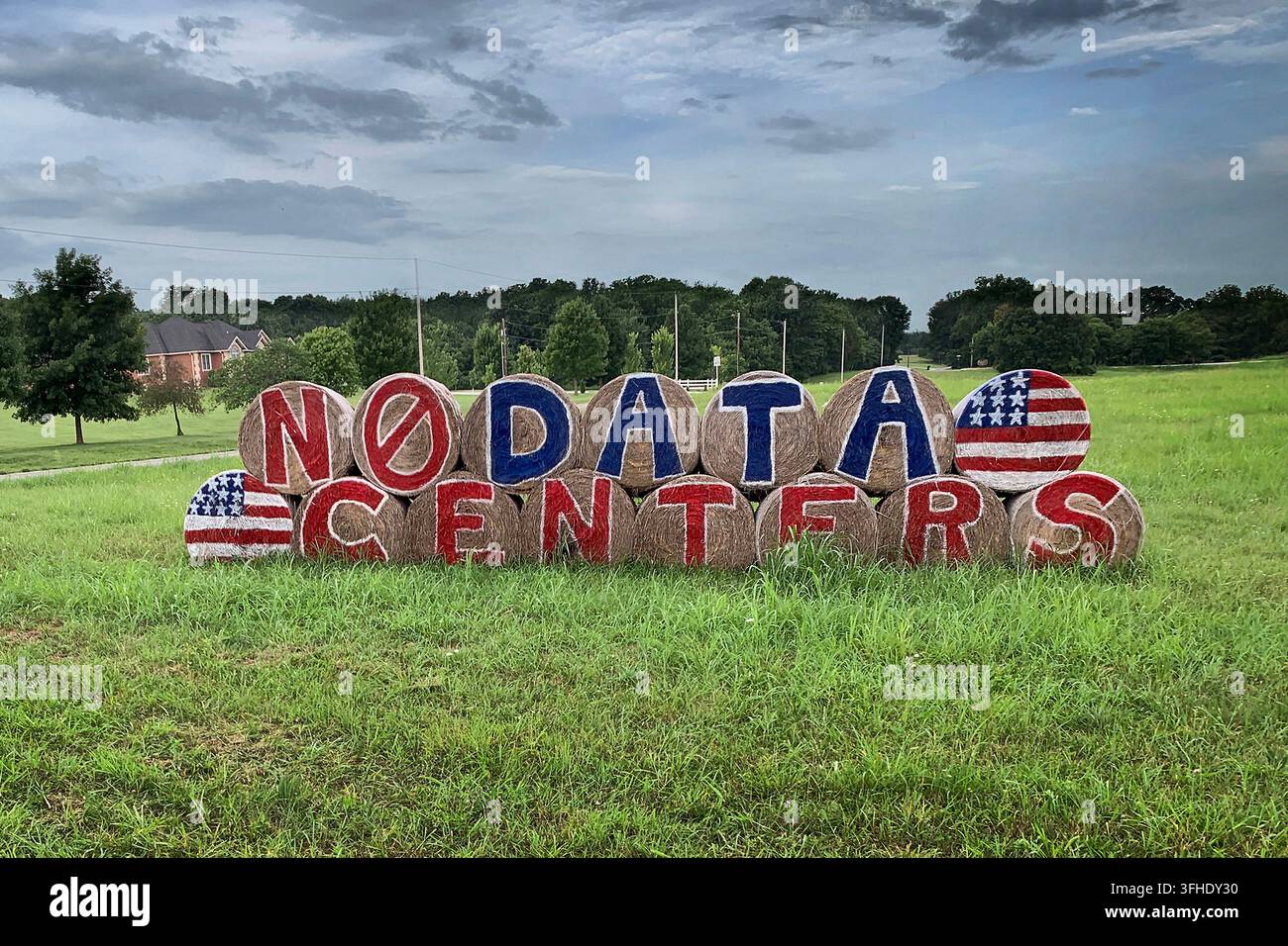 Willard, Missouri - 28 juillet 2026 : Des balles de foin rondes empilées et peintes comme une pancarte de protestation contre les centres de données dans le sud-ouest du Missouri. Éditorial. Banque D'Images