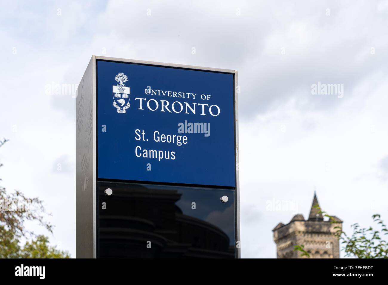 Un panneau de direction du campus avec des bâtiments historiques en pierre en arrière-plan sur le campus St George de l'Université de Toronto dans le centre-ville de Toronto. Banque D'Images