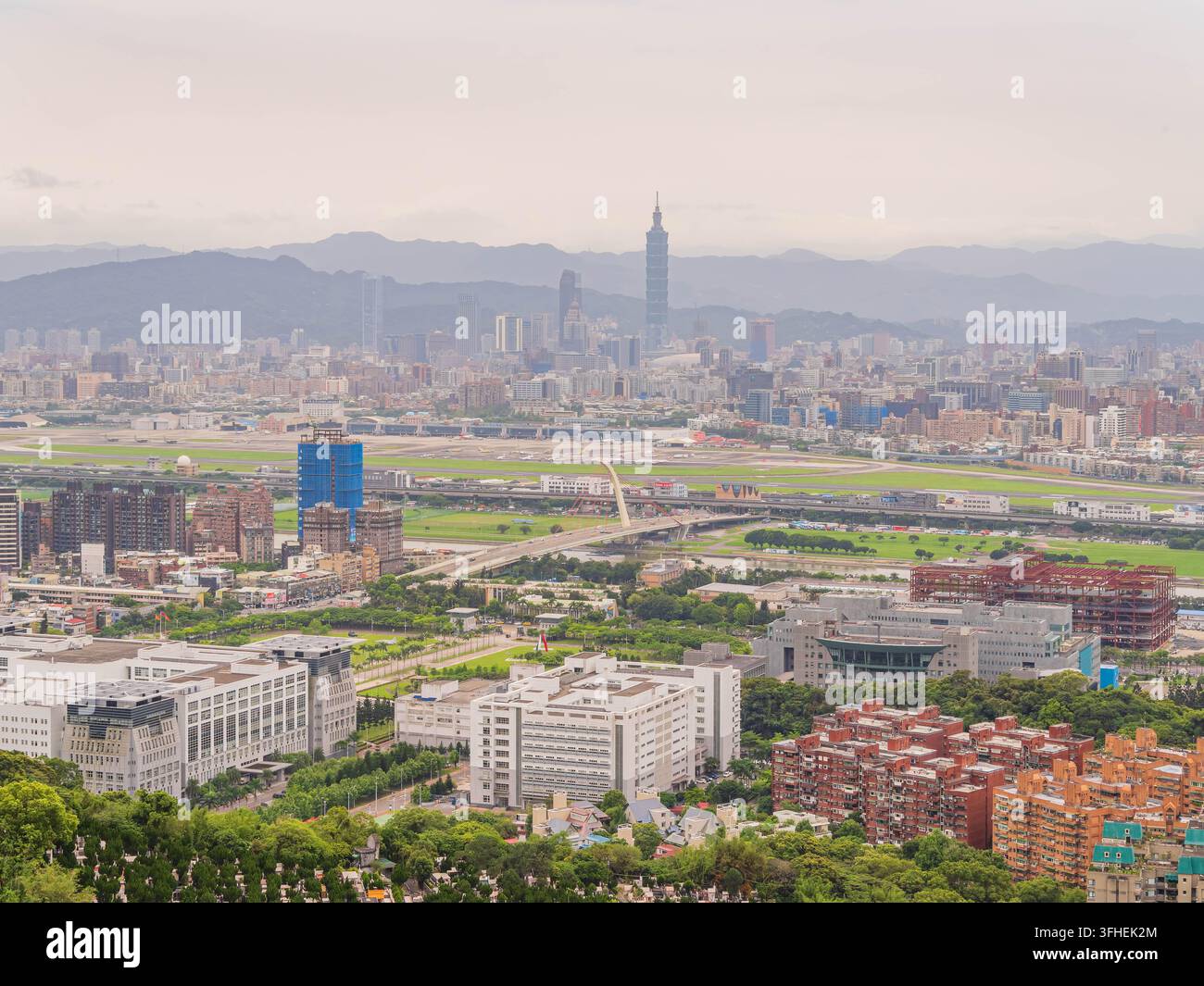 Taipei 101 s’élève au-dessus de l’agglomération urbaine sur un fond de montagnes brumeuses. Banque D'Images