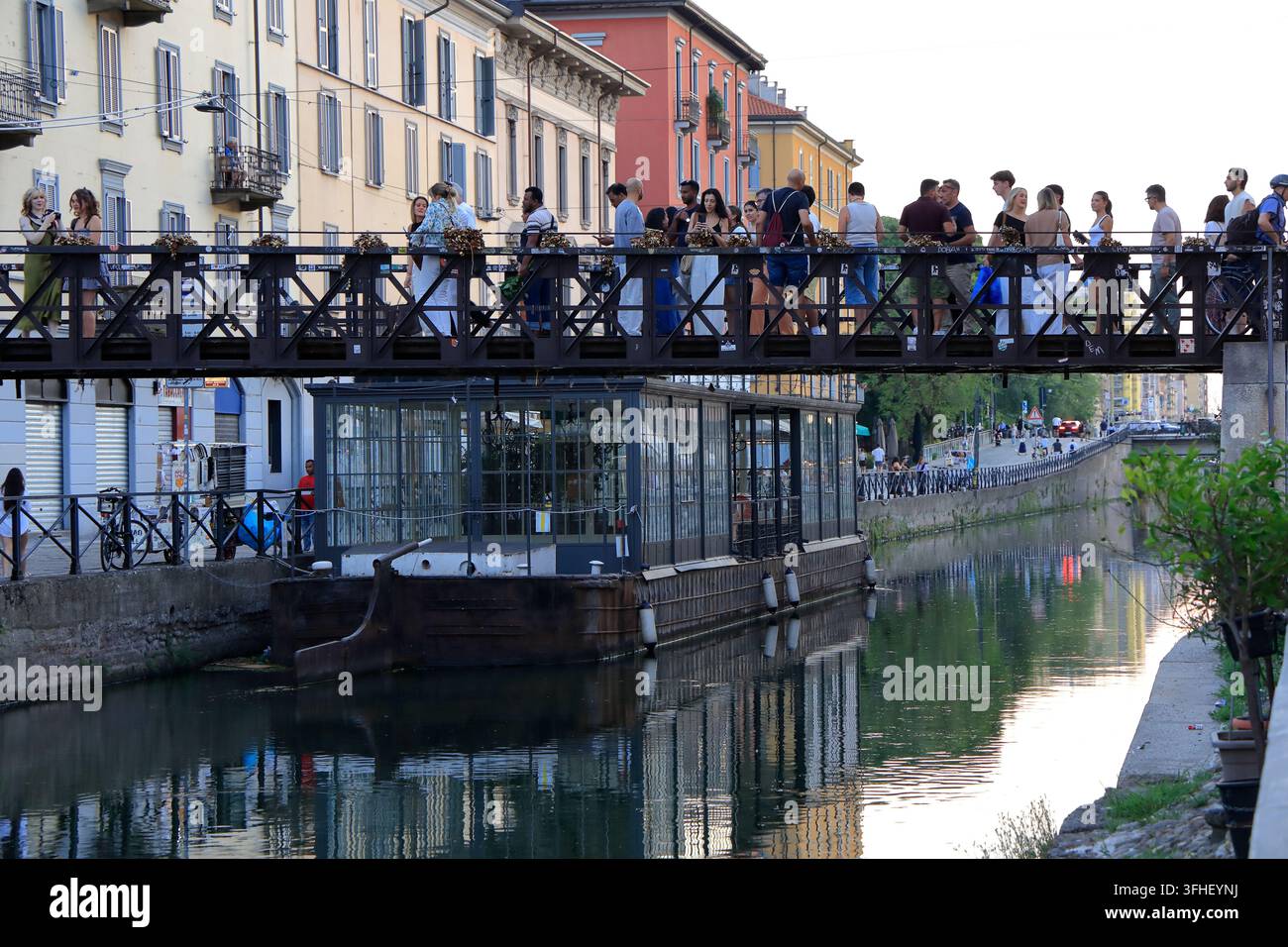 Un pont en acier bondé avec des visiteurs au-dessus du canal Naviglio Grande dans le quartier des canaux Navigli le soir.Milan,Italie Banque D'Images