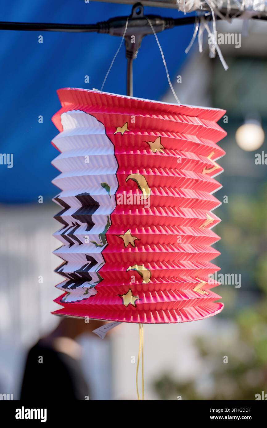 Lanterne décorative en papier accordéon rouge suspendue à l'extérieur avec un éclairage doux Banque D'Images