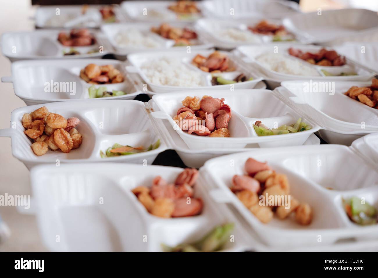 Pile de contenants alimentaires en plastique jetables avec des repas emballés et des saucisses Banque D'Images