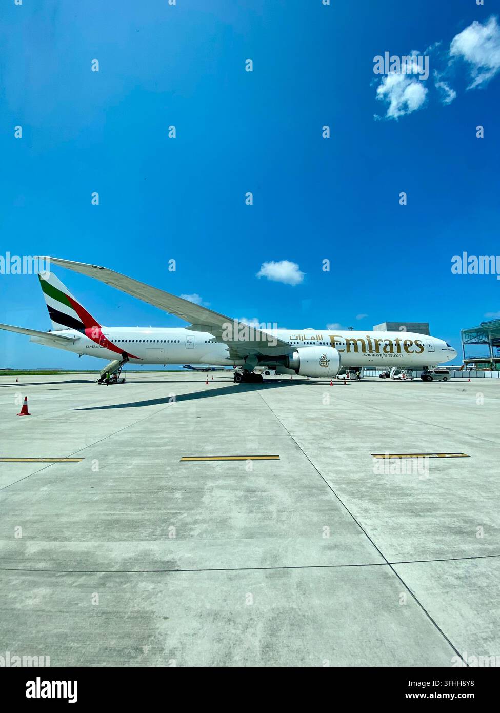 Maldives - 15 septembre 2022 :     Un avion de ligne Emirates est immobilisé sur le tarmac sous un ciel bleu clair. - Image de stock capturée avec un smartphone