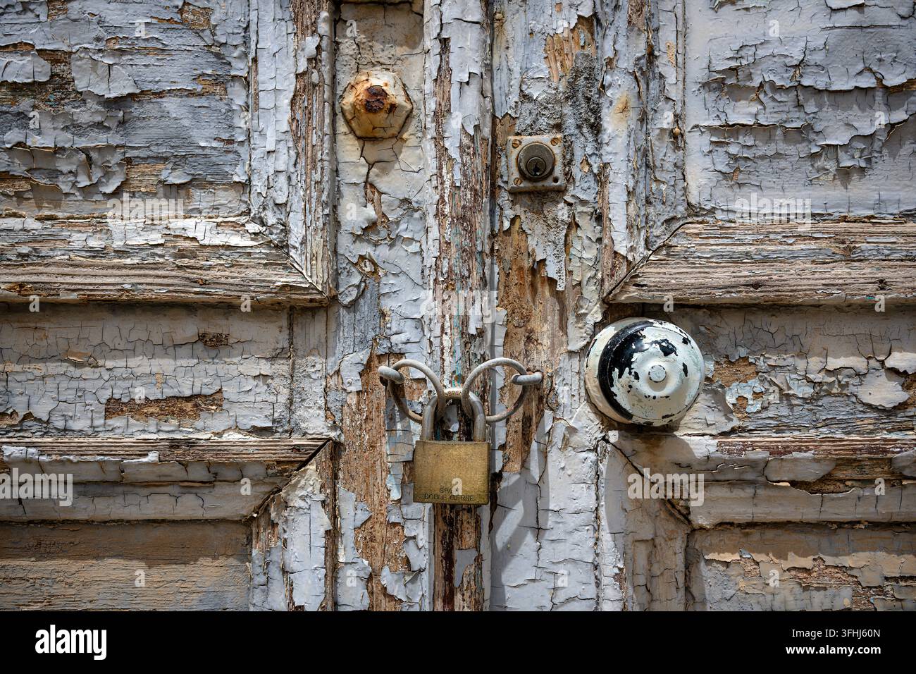 Ancienne porte verrouillée avec peinture écaillée et bois délavé Banque D'Images