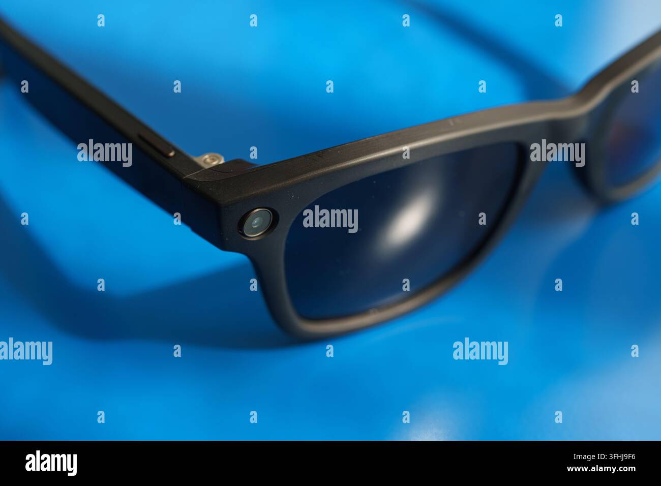 Lunettes intelligentes modernes noires reposant sur un bureau bleu Banque D'Images
