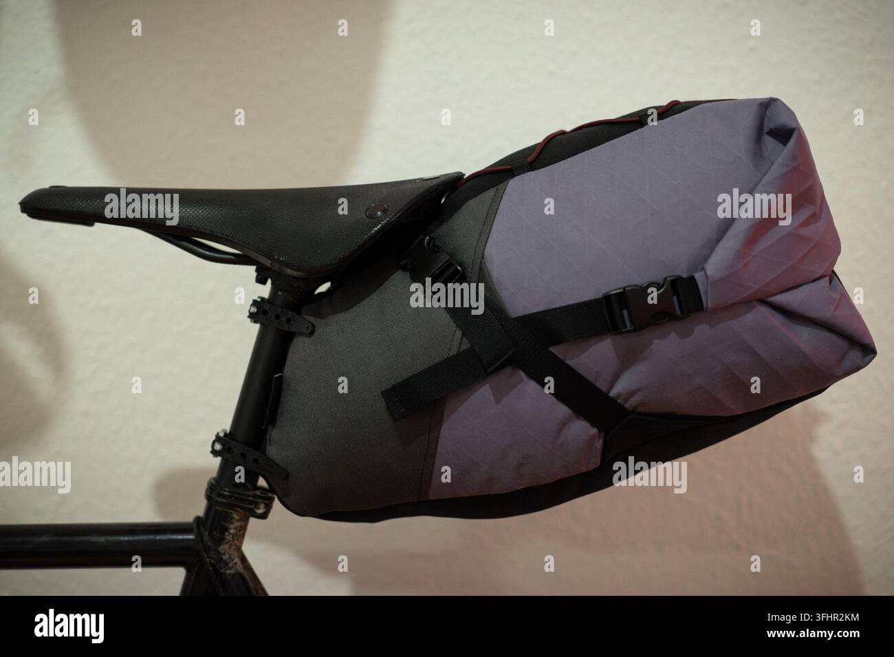 Grande sacoche de bikepacking violette et grise montée sur un vélo Banque D'Images