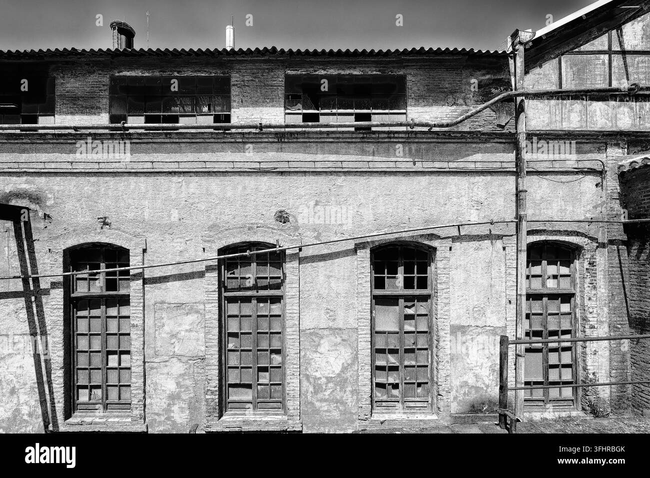 Photo en noir et blanc d'un ancien bâtiment industriel avec des rangées de fenêtres et une architecture délabrée, Fabrica Azucarera Nuestra Senora del Pilar, Muse Banque D'Images