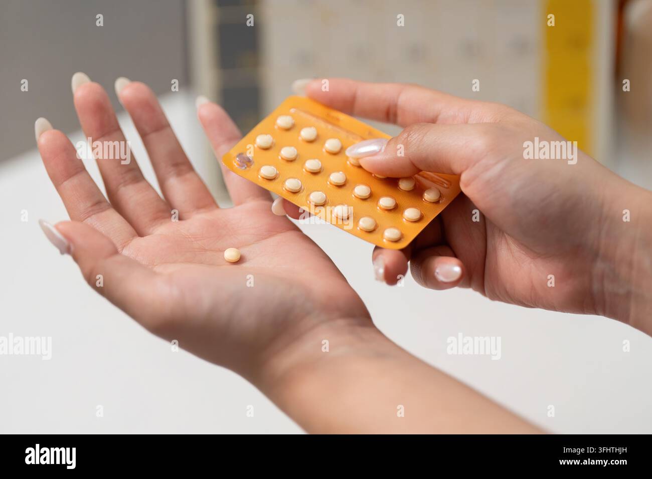 Pilules contraceptives. Une femme tenant une pilule contraceptive d'une plaquette thermoformée. Banque D'Images