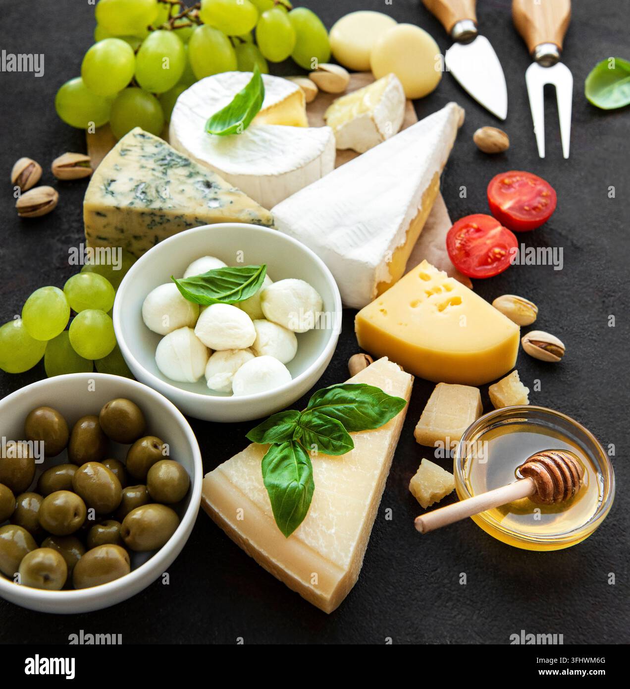 Différents types de fromage, raisins, miel et snacks Banque D'Images