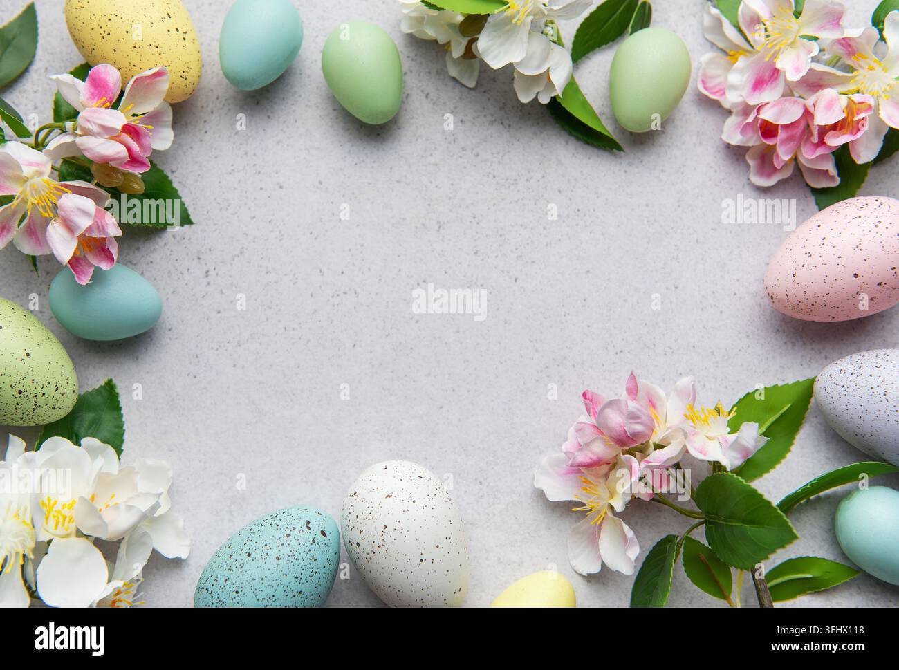 Œufs de Pâques et fleurs pastel disposés en cercle Banque D'Images
