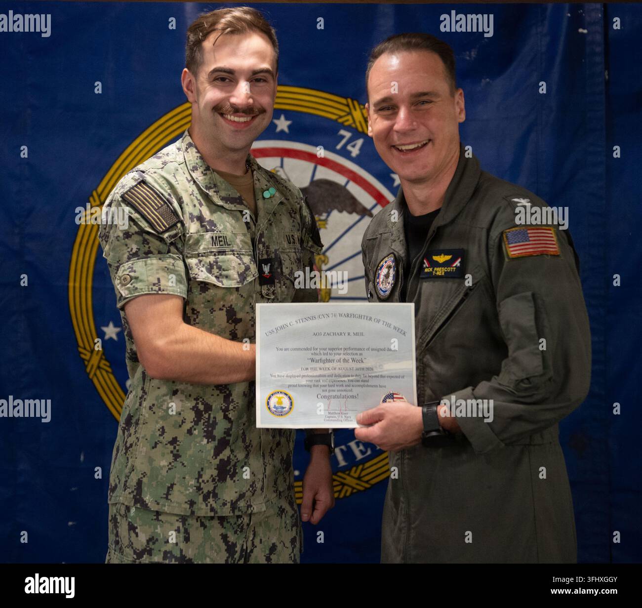 Le capitaine Richard Prescott, officier exécutif de l'USS John C. Stennis, remet le prix Warfighter of the Week à l'Aviation Ordnanceman de 3e classe Zachary Meil à bord du navire, qui est en cours de ravitaillement et de révision complexe au Newport News Shipbuilding. Banque D'Images