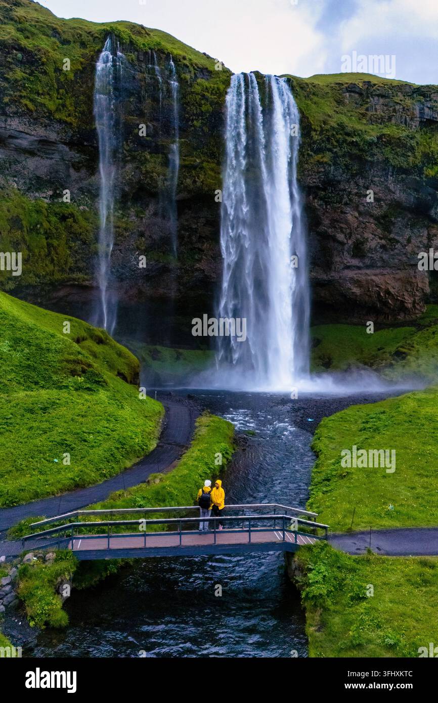 Majestueux cascade de Seljalandsfoss en Islande avec des visiteurs admirant la vue par une journée nuageuse Banque D'Images