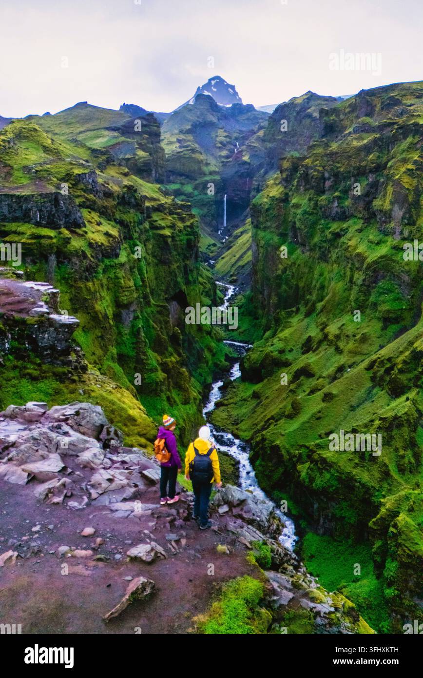 Les randonneurs explorent le canyon époustouflant de Mulagljufur en Islande avec une végétation luxuriante et des cascades Banque D'Images