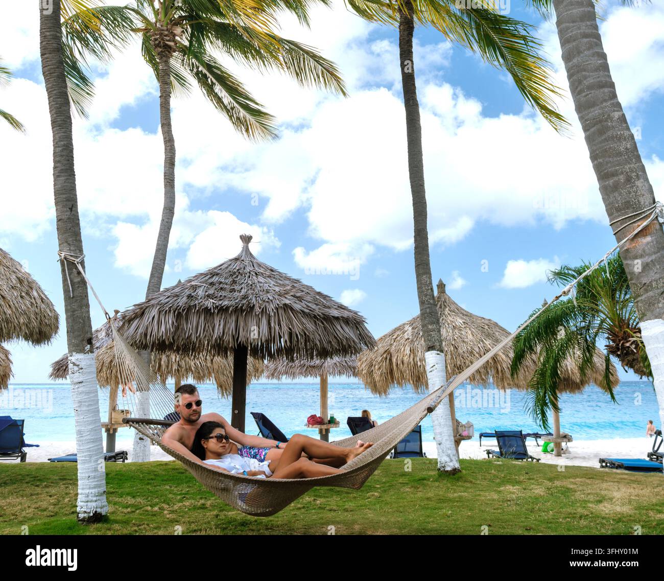 Des amants détendus profitent des vibrations sereines de Divi Beach par une journée ensoleillée à Aruba Banque D'Images
