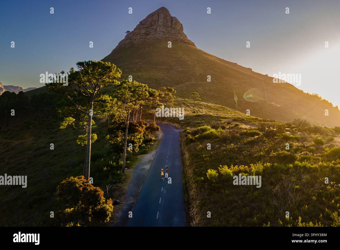 Vue imprenable sur Lions Head avec route pittoresque et randonneurs au Cap, en Afrique du Sud au coucher du soleil Banque D'Images