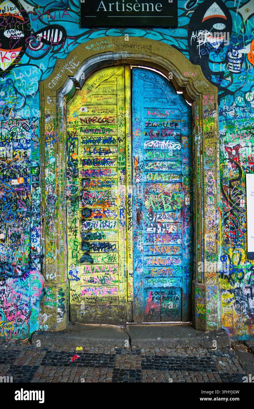 Porte en bois couverte de graffitis et art de rue coloré à côté du célèbre mur de John Lennon à Mala Strana, Prague, République tchèque Banque D'Images