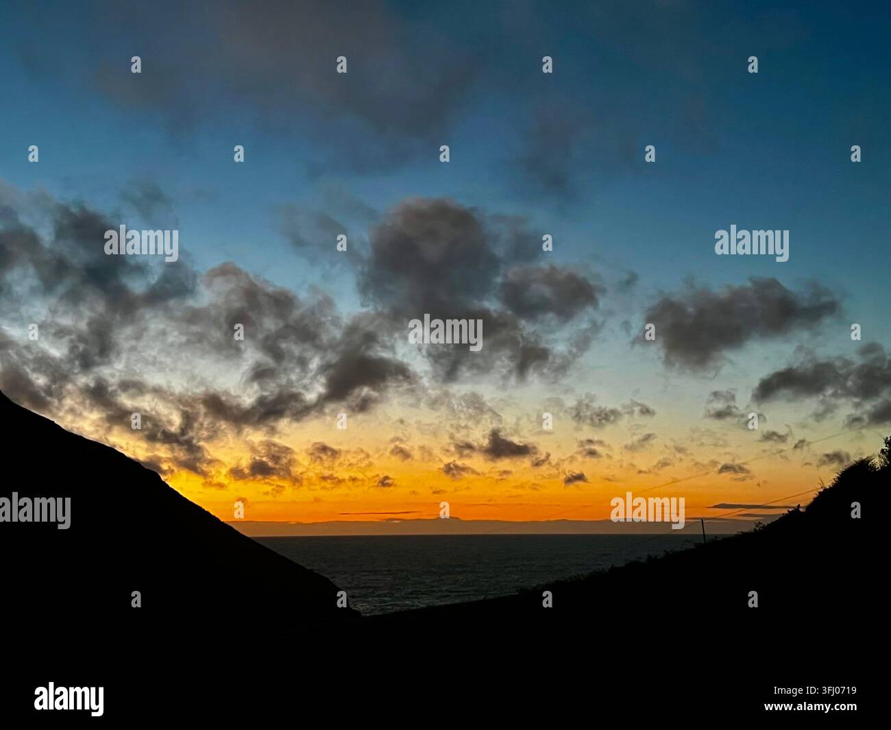 Un coucher de soleil sur la côte ouest du Pays de Galles dans la petite crique cachée de Cwmtydu à Ceredigion, UK Banque D'Images
