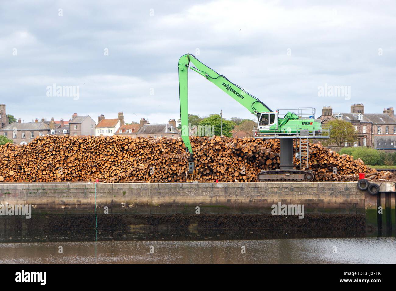 Grue Sennebogen 835 verte manipulant des rondins de bois au Tweed Dock à Berwick-upon-Tweed Banque D'Images