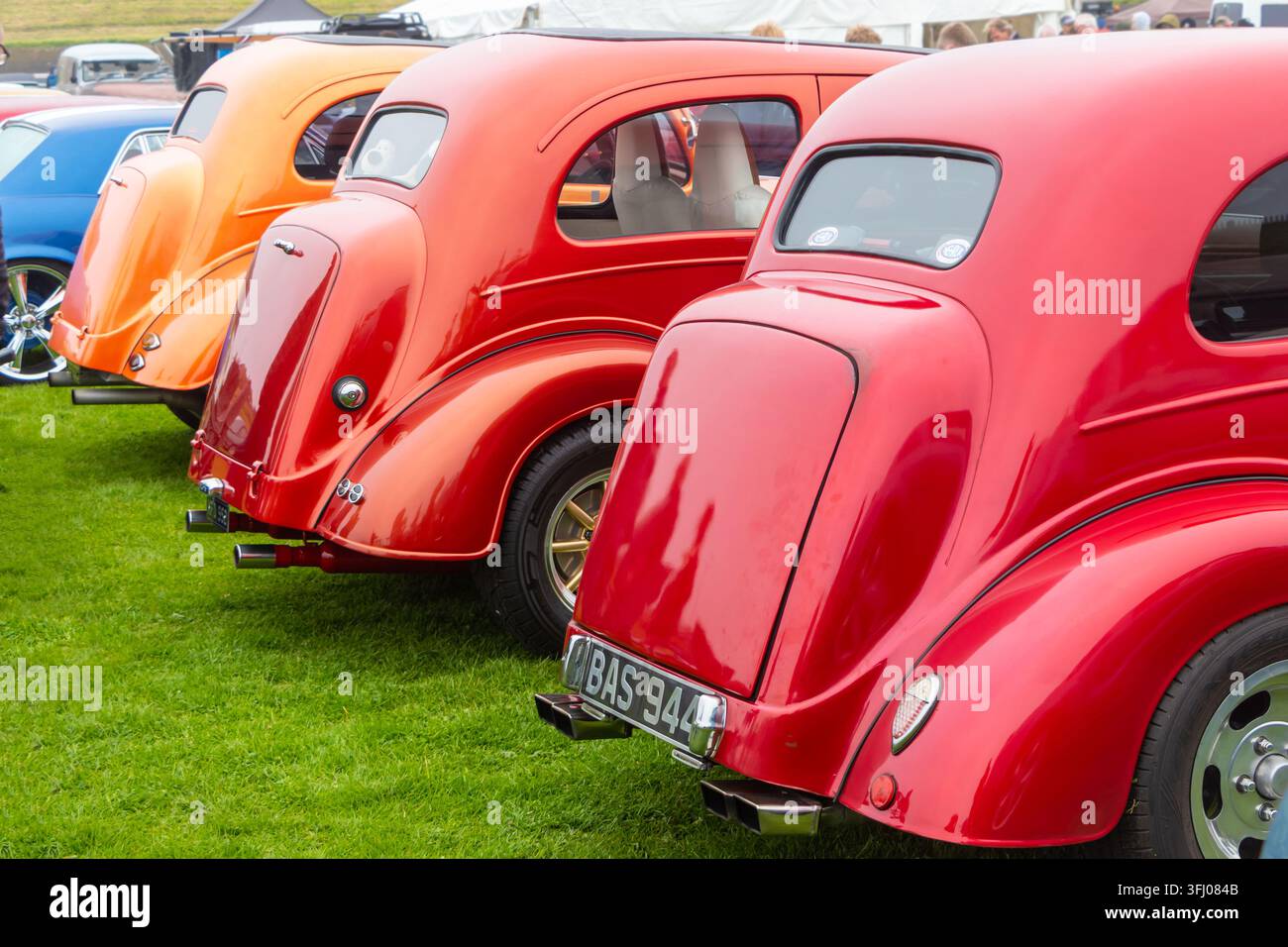 Hot rods Ford Popular et Ford Anglia rouges et orange garés en ligne Banque D'Images