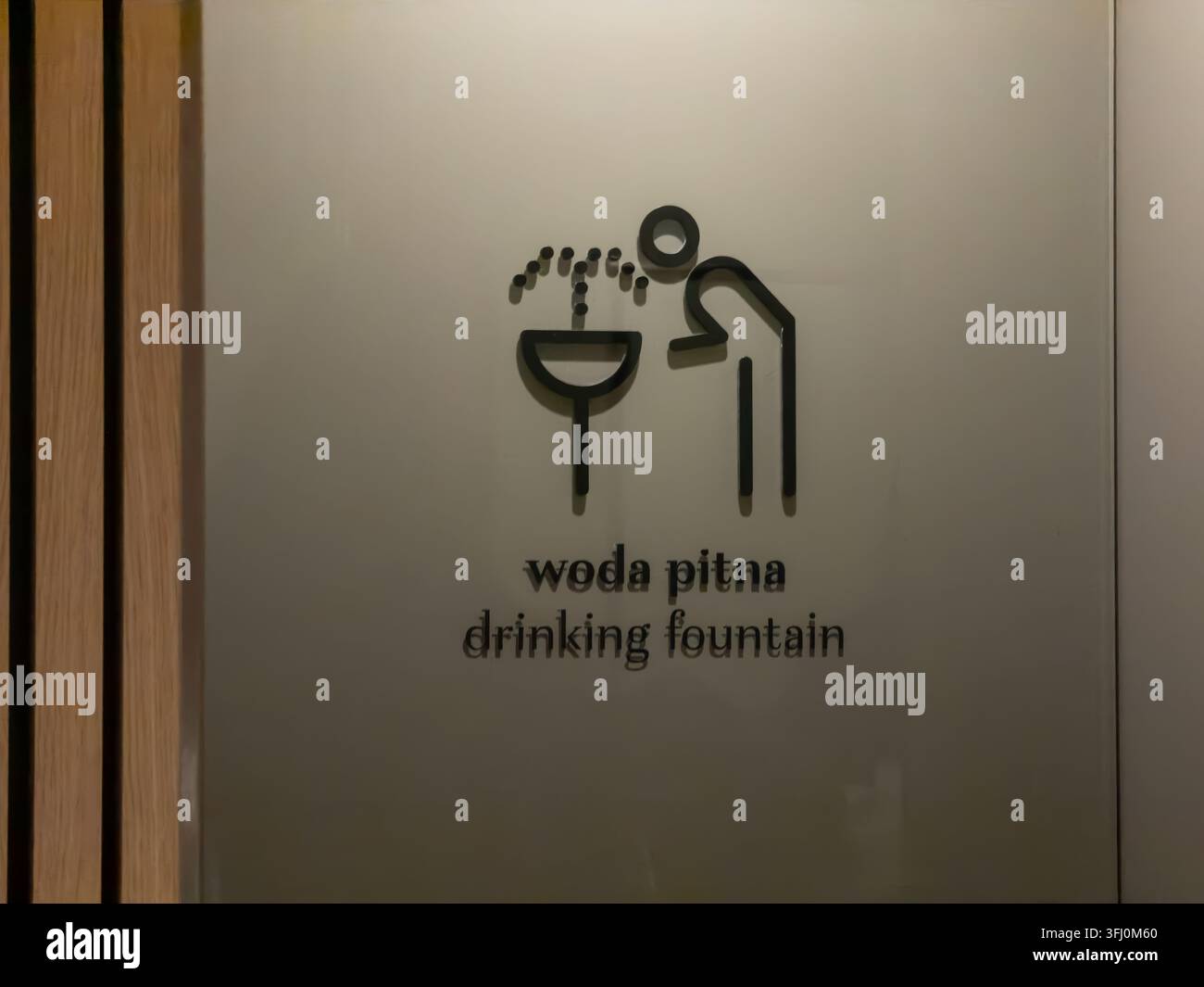 Panneau mural moderne pour fontaine à boire avec un icône propre et des inscriptions bilingues, servant d'aide à la navigation essentielle dans les bâtiments publics pour encou Banque D'Images