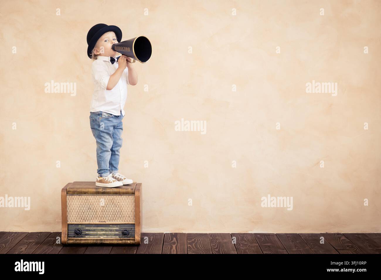 Enfant amusant jouant avec un mégaphone rétro noir Banque D'Images