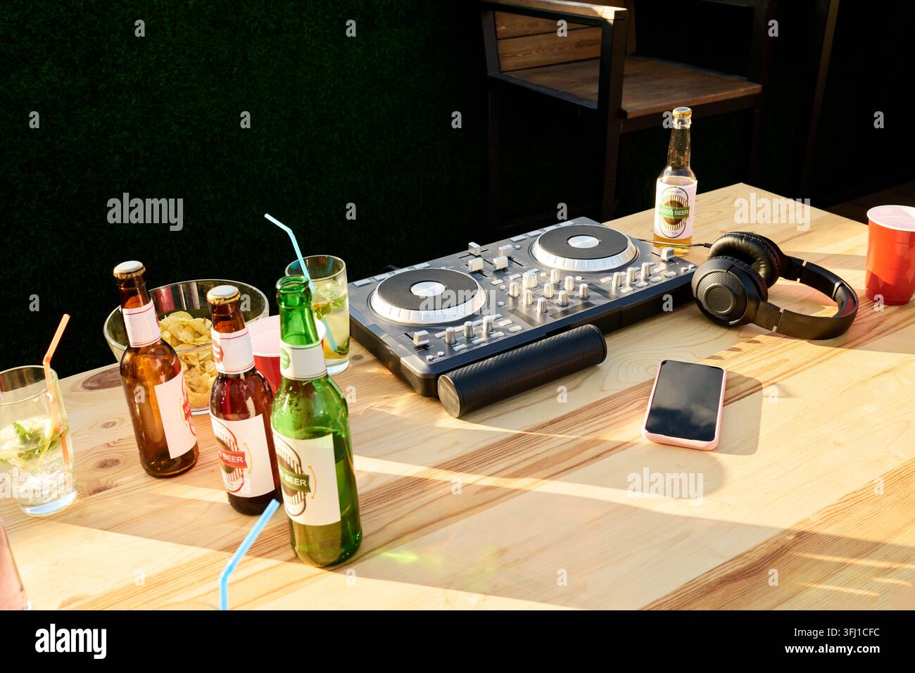 Équipement de DJ avec casque et boissons sur une table en bois à une fête Banque D'Images