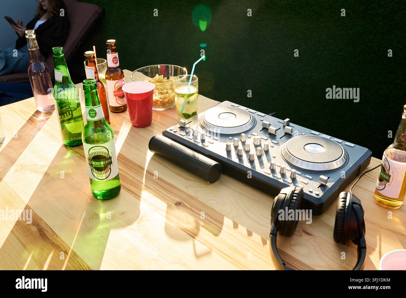Contrôleur DJ avec casque et boissons sur la table lors d'une fête en plein air Banque D'Images
