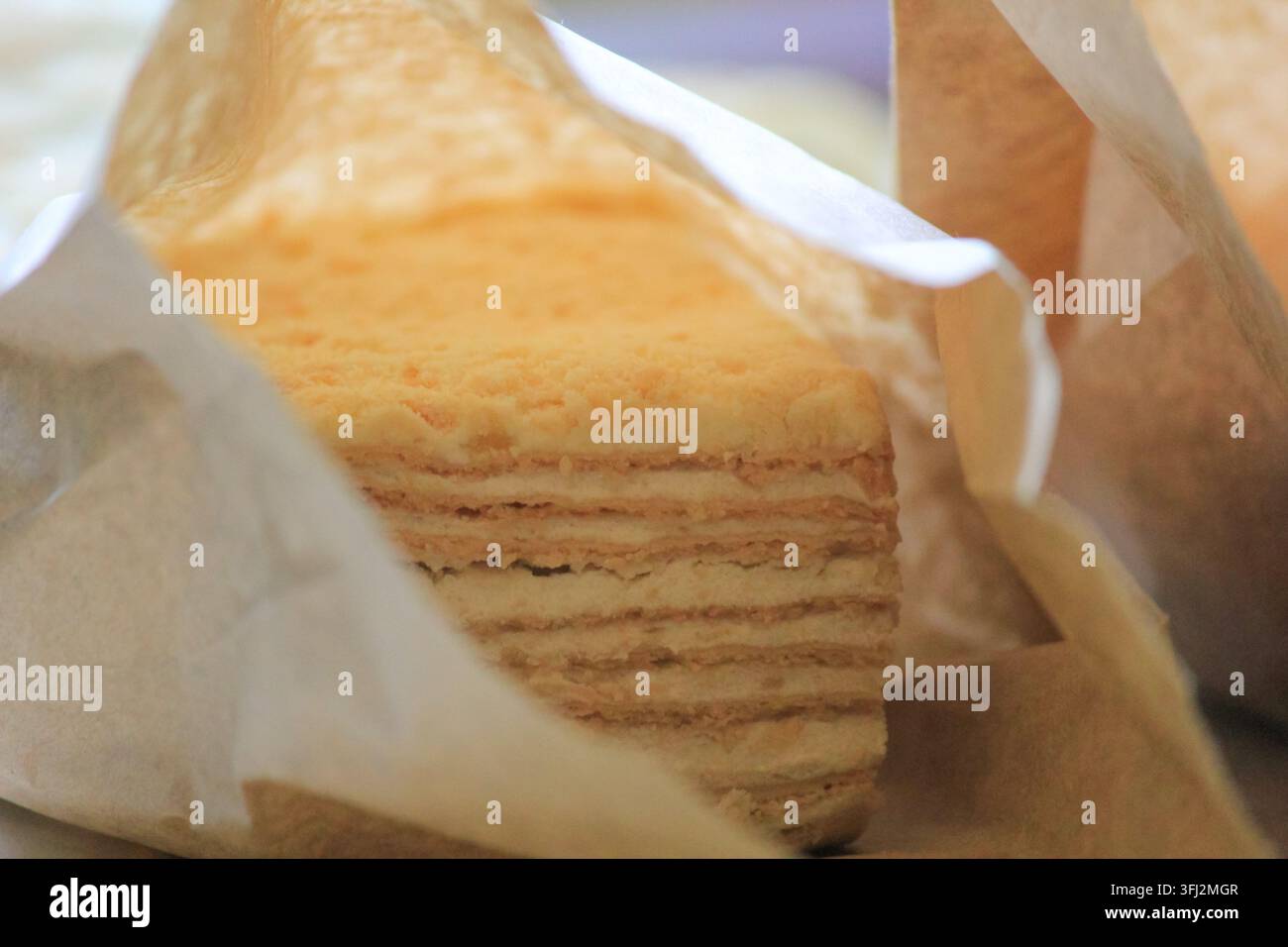 Gâteau fait maison en couches avec de la crème douce à l'intérieur d'un sac en papier rustique pour un en-cas confortable, gros plan Banque D'Images
