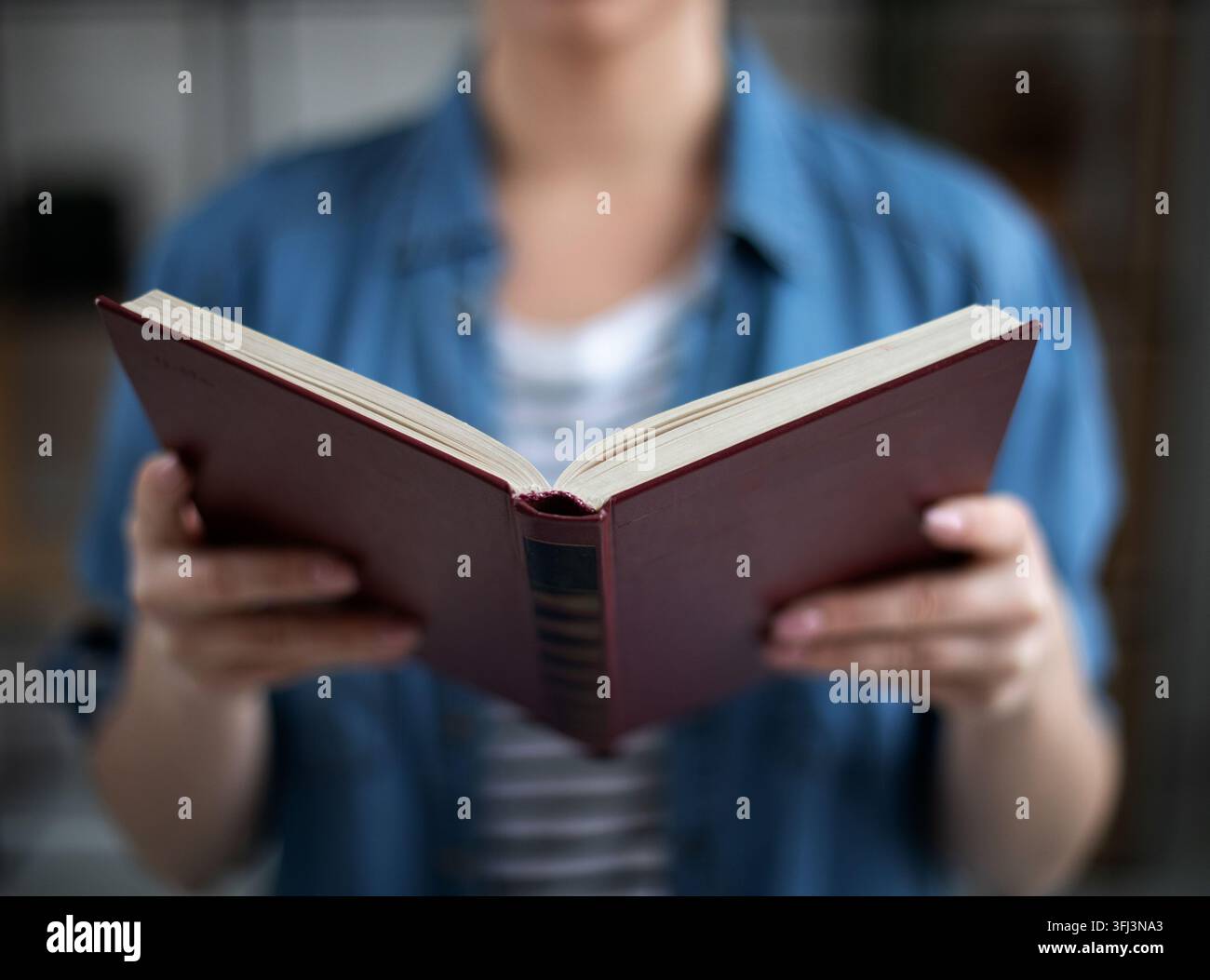 Femme tenant un livre en papier ouvert dans les mains, lisant un roman à succès, concept de librairie Banque D'Images