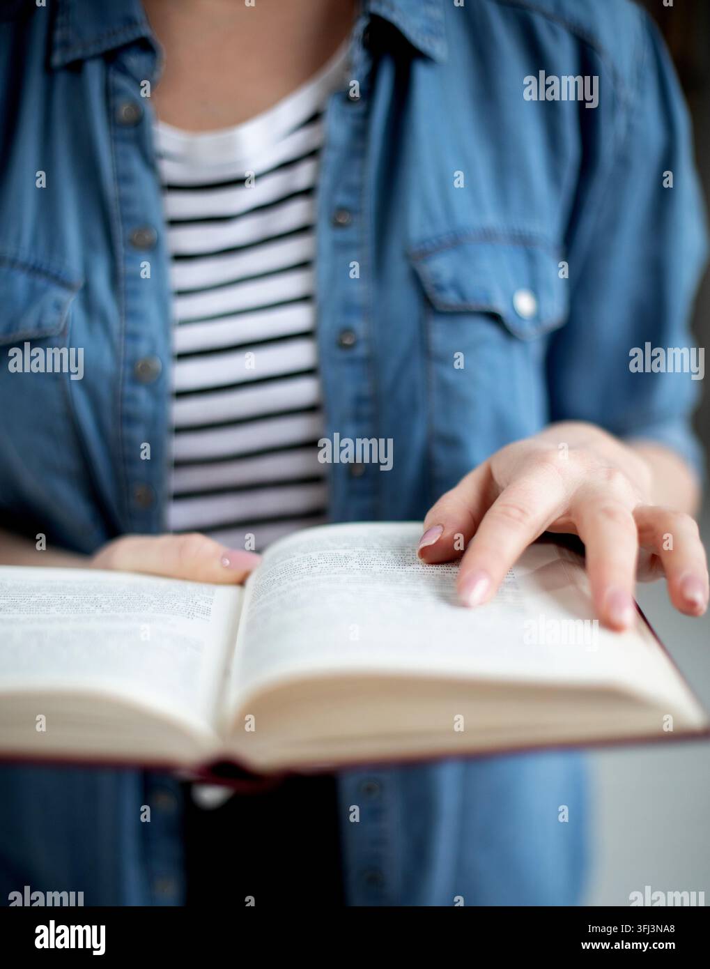 Femme tenant un livre en papier ouvert dans les mains, lisant un roman à succès, concept de librairie Banque D'Images