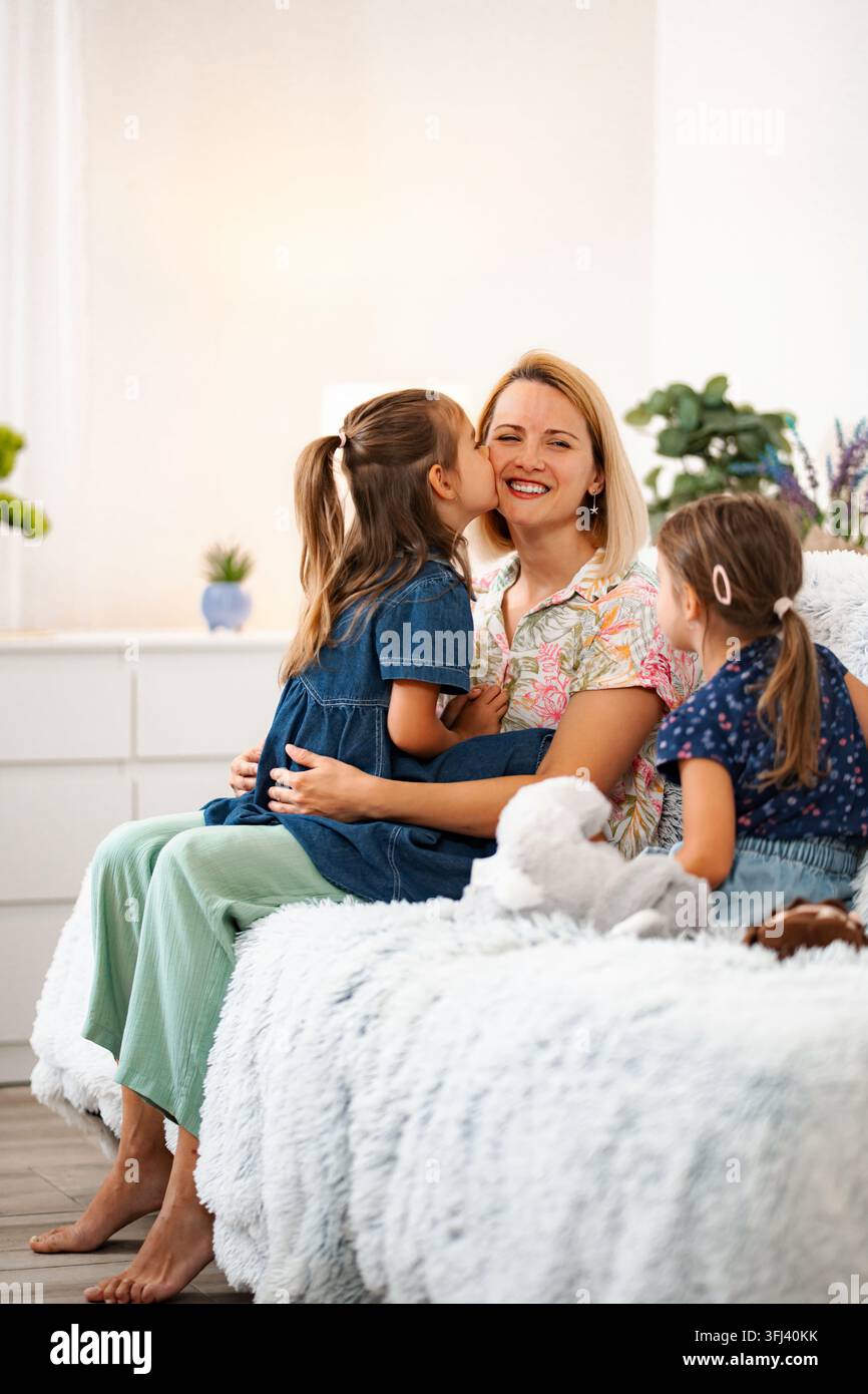 Mère heureuse montrant de l'affection à ses deux filles Banque D'Images