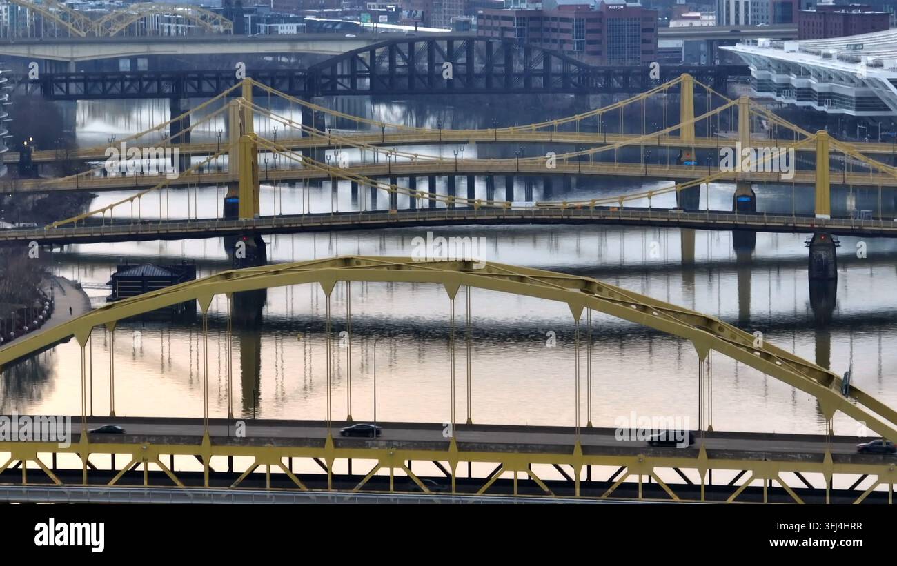 Zoom aérien prolongé des ponts en acier jaunes de Pittsburgh au-dessus de la rivière Allegheny. Prise de vue aérienne avec facteur 7 par inclinaison de drone vers le haut, Pennsylvanie. Banque D'Images