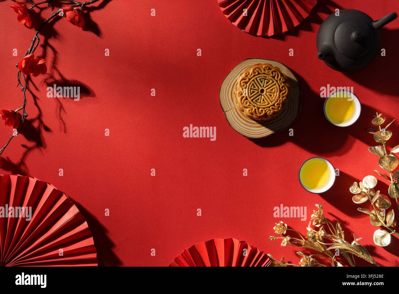 Gâteau de lune du Festival du Milieu de l'automne avec du thé sur fond rouge pour la célébration des fêtes Banque D'Images