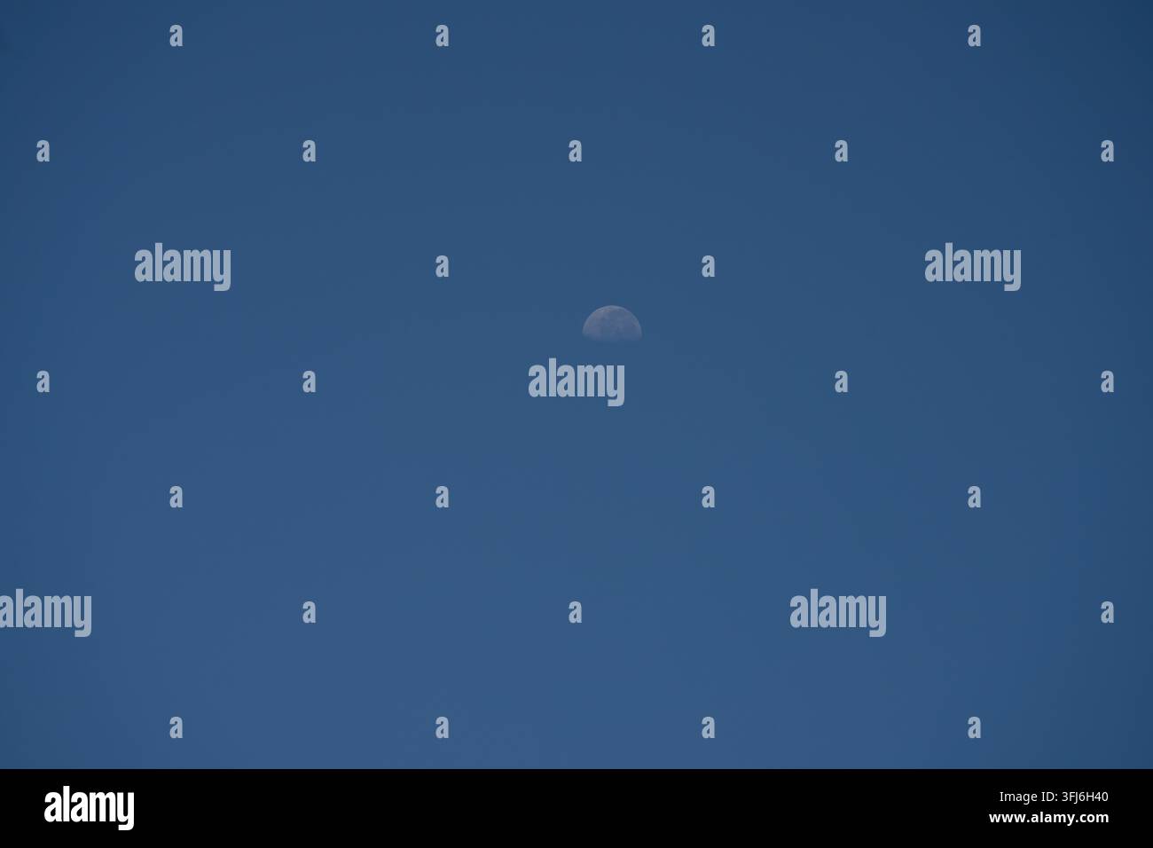 Demi-lune brillant dans un ciel bleu pâle diurne, Y Ty, Lao Cai, Vietnam Banque D'Images