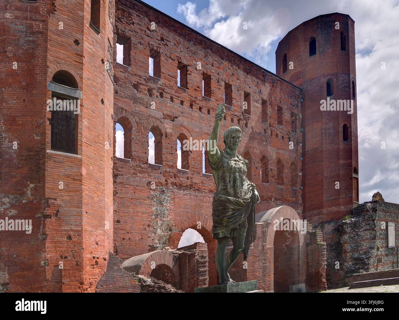 Turin, Itlay - 15 mai 2026 : Statue en bronze de César Auguste devant les anciennes portes de la ville du Palatin avec les tours adjacentes à Turin, en Italie. Banque D'Images