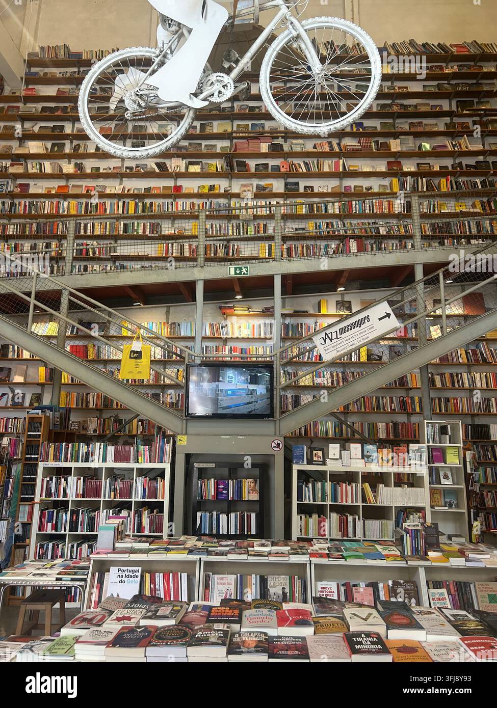 Intérieur de la librairie Ler Devagar à la LX Factory à Lisbonne, Portugal, présentant des étagères à livres imposantes, une architecture industrielle et la distinctive suspen Banque D'Images