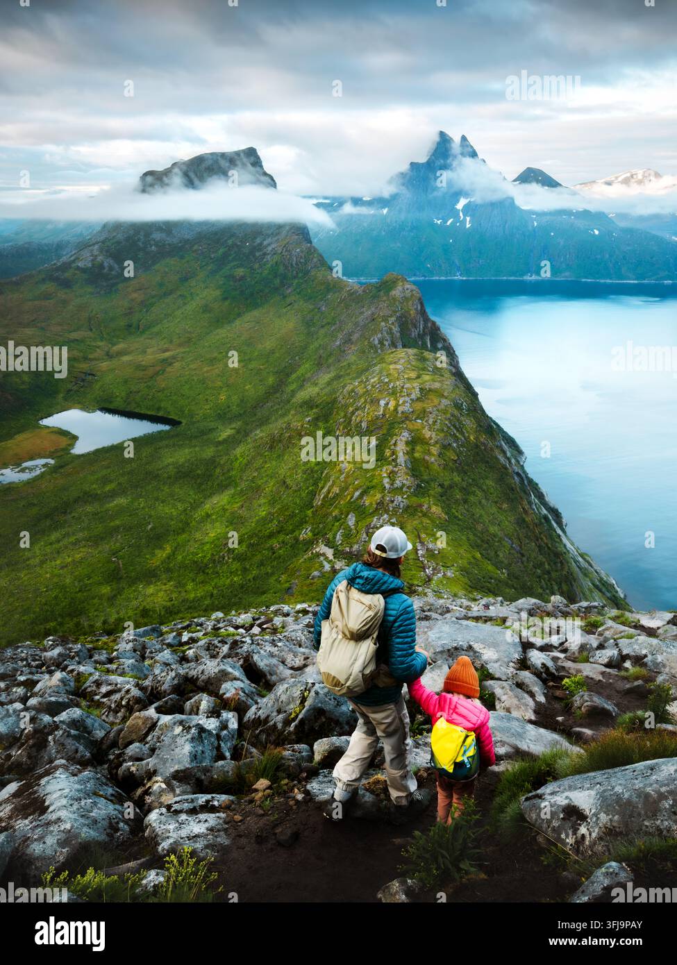 Voyage en famille père et enfant escaladant des montagnes en Norvège vacances actives, parent et enfant explorent des sentiers de randonnée à Senja ensemble en plein air aventure Banque D'Images