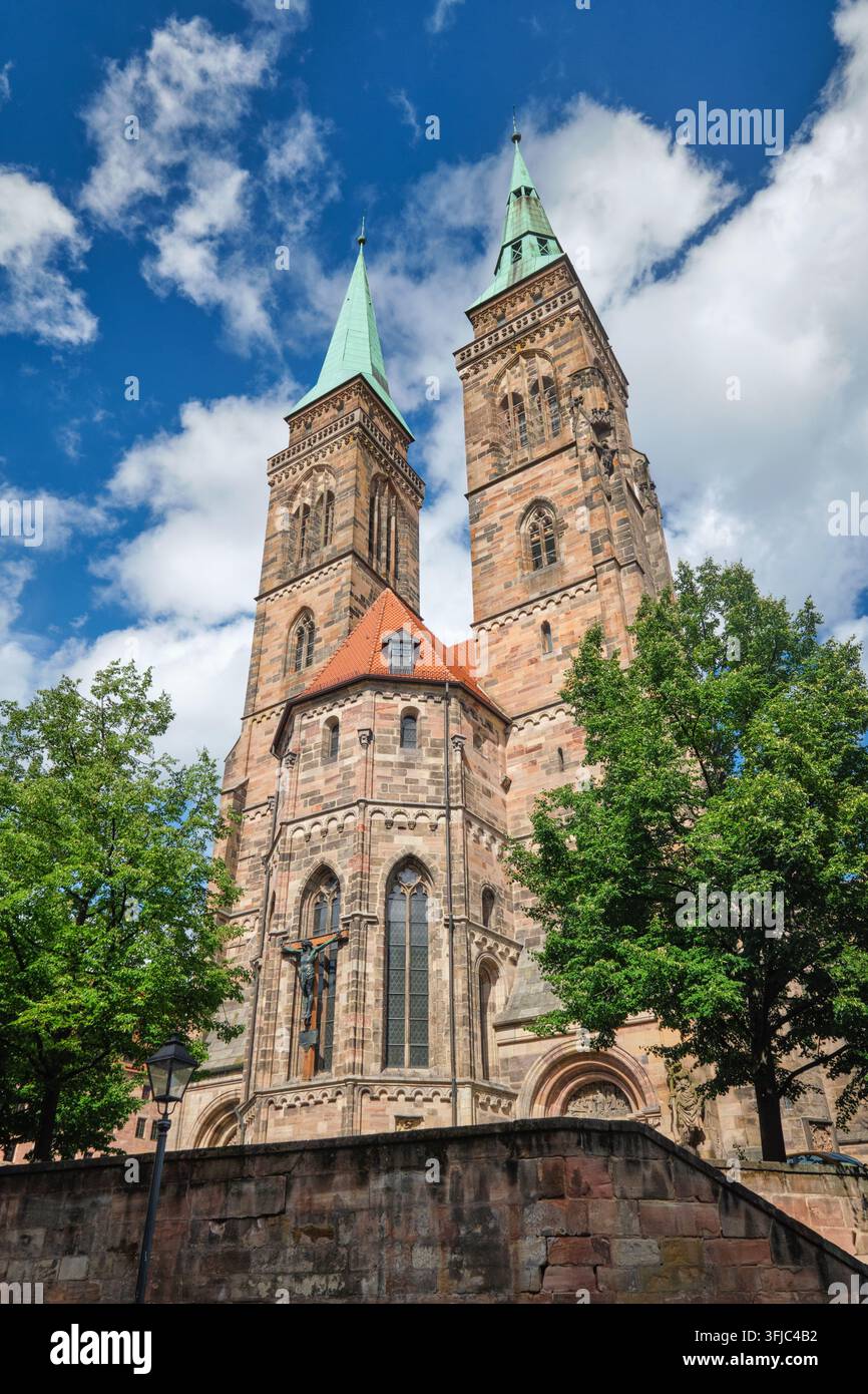 Église Saint-Sébald à Nuremberg, Allemagne, avec deux tours d'église en pierre, des toits en cuivre vert et des nuages au-dessus de la vieille ville Banque D'Images