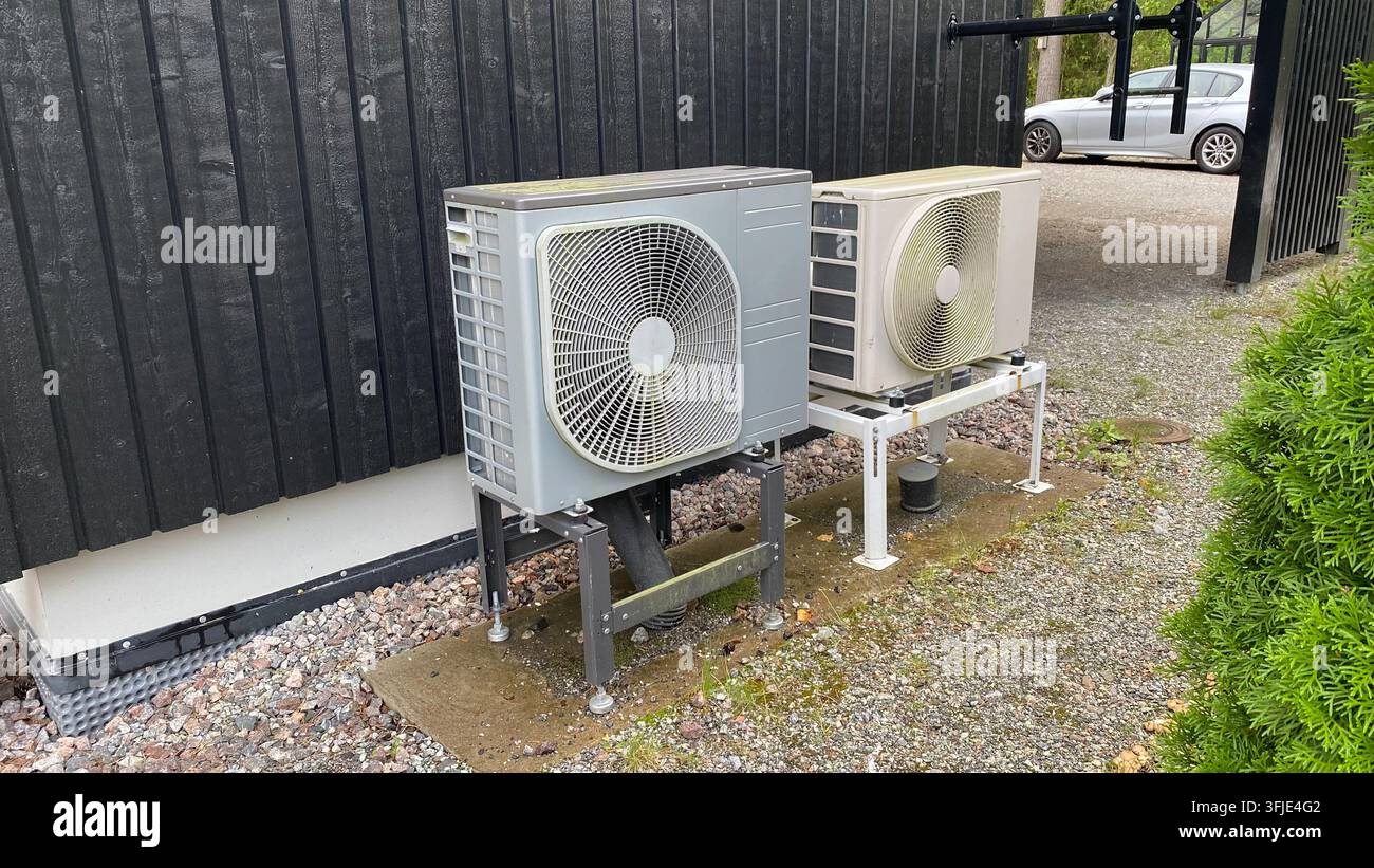 Unités de pompes à chaleur extérieures installées à côté d'une maison résidentielle pour un système de chauffage et de refroidissement écoénergétique Banque D'Images