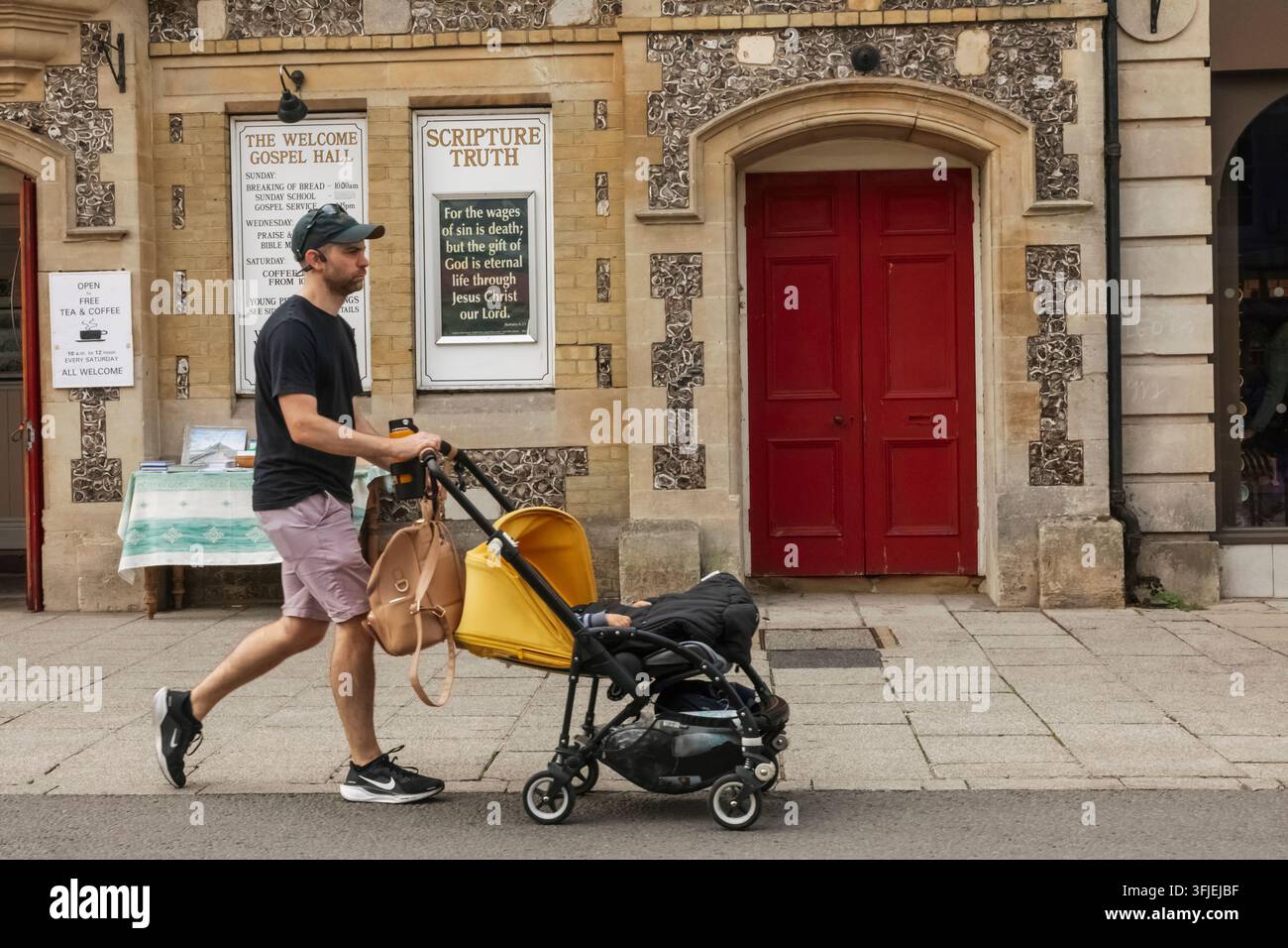 Angleterre, Hampshire, Winchester, La High Street, Scène de rue avec un jeune homme poussant une poussette Banque D'Images