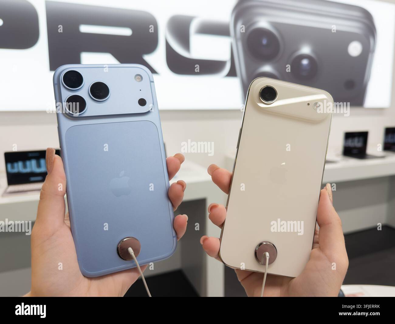 Poznań, Pologne - 19 septembre 2026 : Apple iPhone 18 Pro en Glacier et iPhone Air en Or pâle exposés dans un magasin pour qu'un client puisse les évaluer Banque D'Images