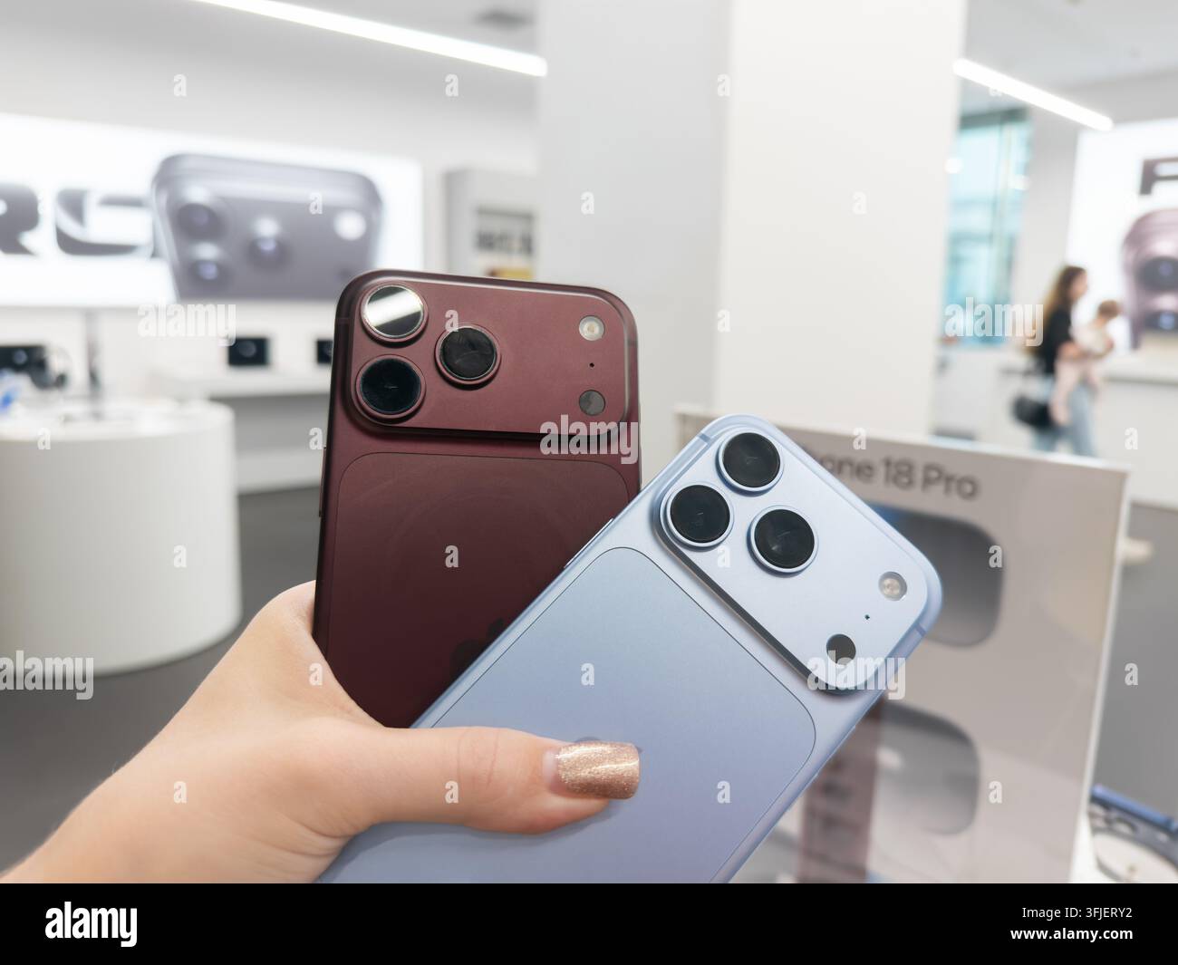 Poznań, Pologne – 19 septembre 2026 : Téléphones Apple iPhone 18 Pro en finitions Bourgogne et Glacier exposés dans un environnement de vente au détail lumineux, mise en avant Banque D'Images