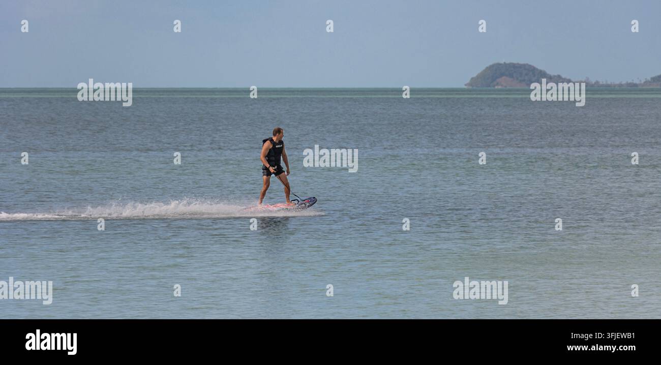 Homme sur une planche hydrofoil électrique au motif Union Jack au large de Koh Samui dans le golfe de Thaïlande Banque D'Images