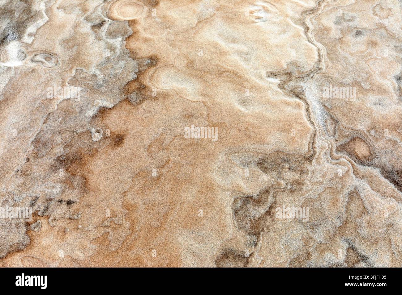 Un gros plan abstrait de motifs complexes ondulés par le vent et de textures minérales fines sur les sols de sable blanc des Lencois Maranhenses, au Brésil. Banque D'Images