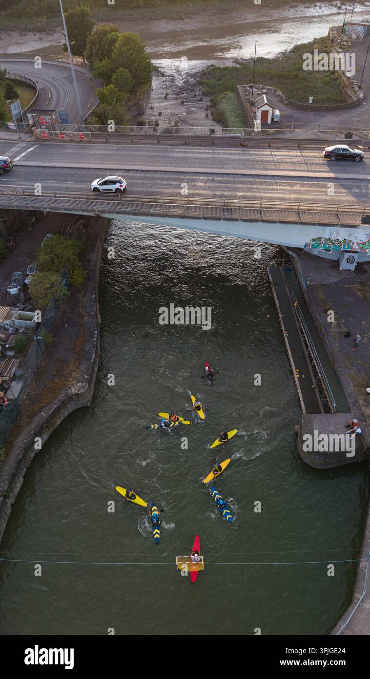 Vue aérienne de personnes jouant au polo en kayak dans des kayaks colorés sous le Plimsoll Swingbridge, avec la rivière Avon en arrière-plan, à Bristol, en Angleterre Banque D'Images