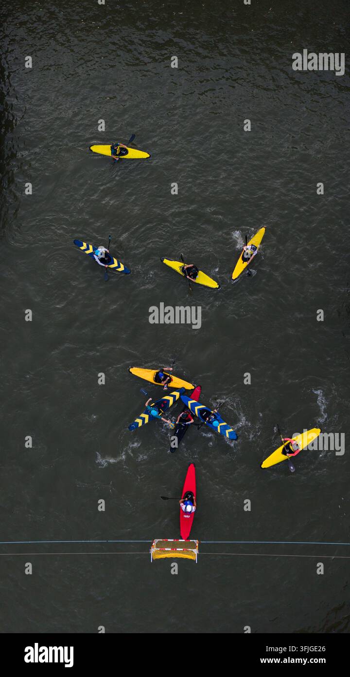 Vue aérienne par le dessus d'un match de polo en canoë avec des joueurs dans des kayaks colorés jouant près du but au Cumberland Basin à Bristol, en Angleterre Banque D'Images